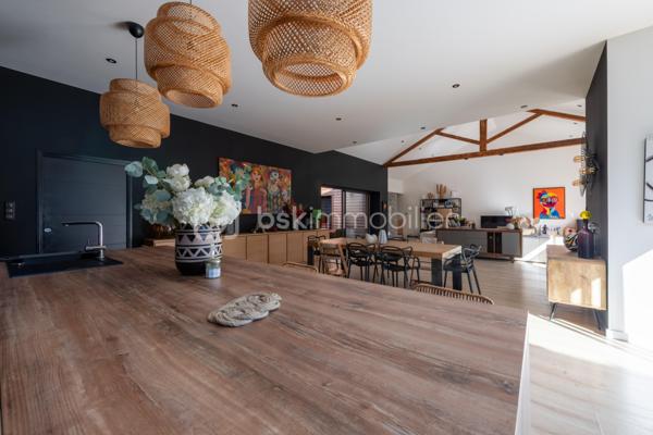De l’espace pour recevoir, un patio pour s’isoler, une piscine pour profiter des beaux jours… À proximité immédiate du centre-ville de Roanne, cette maison de ville à l’esprit loft conjugue volumes remarquables et douceur de vivre, au calme, en retrait des axes passants.

Réhabilitée en 2021, elle développe environ une surface habitable de 224 m² habitables (surface carrez : 199 m²), sur un terrain clos et arboré de 746 m². Poutres apparentes, belles hauteurs sous plafond et larges ouvertures soulignent le caractère des lieux.

Au cœur de la maison, une pièce de vie d’environ 110 m² réunit cuisine équipée avec îlot central, espace repas et vaste salon. 

Ouverte sur le jardin et la piscine d’un côté, sur le patio intérieur de l’autre, elle invite à vivre autant dedans que dehors.

Le rez-de-chaussée accueille deux chambres donnant sur le patio, dont une suite parentale avec dressing et salle d’eau, ainsi qu’une buanderie et un WC indépendant.

À l’étage, une chambre, une salle de bains avec WC et une seconde pièce disposant d’un point d’eau et d’un WC permettent d’adapter les espaces à vos besoins : quatrième chambre, bureau ou salle de jeux.

À l’extérieur, terrasse, jardin et piscine au sel de 7 × 4 m composent un cadre idéal pour les repas d’été et les moments en famille. Un double carport avec espace de stockage à l’étage complète l’ensemble.

Classée A au DPE, la maison bénéficie d’une pompe à chaleur air/eau, d’un chauffage au sol, de menuiseries à double vitrage renforcé et d’un portail motorisé.

À proximité des écoles, des commerces et de la gare, une maison pour ceux qui souhaitent profiter de la ville tout en conservant de l’espace et un véritable extérieur.