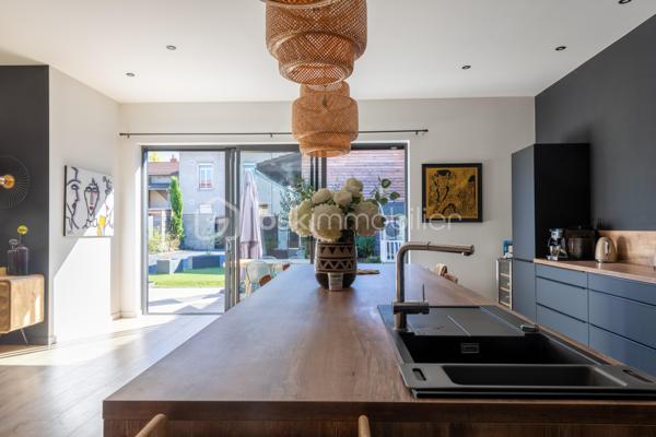 De l’espace pour recevoir, un patio pour s’isoler, une piscine pour profiter des beaux jours… À proximité immédiate du centre-ville de Roanne, cette maison de ville à l’esprit loft conjugue volumes remarquables et douceur de vivre, au calme, en retrait des axes passants.

Réhabilitée en 2021, elle développe environ une surface habitable de 224 m² habitables (surface carrez : 199 m²), sur un terrain clos et arboré de 746 m². Poutres apparentes, belles hauteurs sous plafond et larges ouvertures soulignent le caractère des lieux.

Au cœur de la maison, une pièce de vie d’environ 110 m² réunit cuisine équipée avec îlot central, espace repas et vaste salon. 

Ouverte sur le jardin et la piscine d’un côté, sur le patio intérieur de l’autre, elle invite à vivre autant dedans que dehors.

Le rez-de-chaussée accueille deux chambres donnant sur le patio, dont une suite parentale avec dressing et salle d’eau, ainsi qu’une buanderie et un WC indépendant.

À l’étage, une chambre, une salle de bains avec WC et une seconde pièce disposant d’un point d’eau et d’un WC permettent d’adapter les espaces à vos besoins : quatrième chambre, bureau ou salle de jeux.

À l’extérieur, terrasse, jardin et piscine au sel de 7 × 4 m composent un cadre idéal pour les repas d’été et les moments en famille. Un double carport avec espace de stockage à l’étage complète l’ensemble.

Classée A au DPE, la maison bénéficie d’une pompe à chaleur air/eau, d’un chauffage au sol, de menuiseries à double vitrage renforcé et d’un portail motorisé.

À proximité des écoles, des commerces et de la gare, une maison pour ceux qui souhaitent profiter de la ville tout en conservant de l’espace et un véritable extérieur.