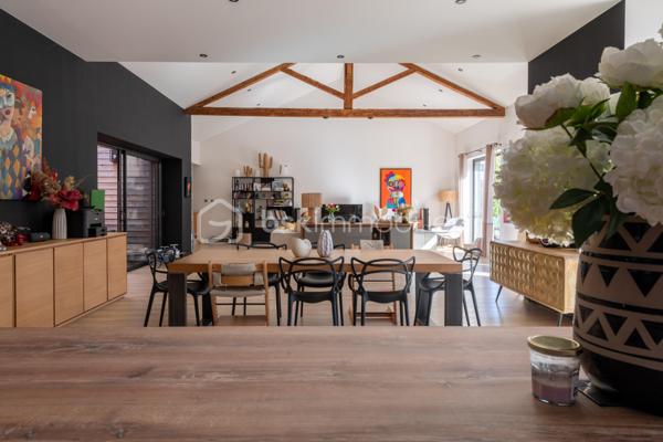 De l’espace pour recevoir, un patio pour s’isoler, une piscine pour profiter des beaux jours… À proximité immédiate du centre-ville de Roanne, cette maison de ville à l’esprit loft conjugue volumes remarquables et douceur de vivre, au calme, en retrait des axes passants.

Réhabilitée en 2021, elle développe environ une surface habitable de 224 m² habitables (surface carrez : 199 m²), sur un terrain clos et arboré de 746 m². Poutres apparentes, belles hauteurs sous plafond et larges ouvertures soulignent le caractère des lieux.

Au cœur de la maison, une pièce de vie d’environ 110 m² réunit cuisine équipée avec îlot central, espace repas et vaste salon. 

Ouverte sur le jardin et la piscine d’un côté, sur le patio intérieur de l’autre, elle invite à vivre autant dedans que dehors.

Le rez-de-chaussée accueille deux chambres donnant sur le patio, dont une suite parentale avec dressing et salle d’eau, ainsi qu’une buanderie et un WC indépendant.

À l’étage, une chambre, une salle de bains avec WC et une seconde pièce disposant d’un point d’eau et d’un WC permettent d’adapter les espaces à vos besoins : quatrième chambre, bureau ou salle de jeux.

À l’extérieur, terrasse, jardin et piscine au sel de 7 × 4 m composent un cadre idéal pour les repas d’été et les moments en famille. Un double carport avec espace de stockage à l’étage complète l’ensemble.

Classée A au DPE, la maison bénéficie d’une pompe à chaleur air/eau, d’un chauffage au sol, de menuiseries à double vitrage renforcé et d’un portail motorisé.

À proximité des écoles, des commerces et de la gare, une maison pour ceux qui souhaitent profiter de la ville tout en conservant de l’espace et un véritable extérieur.