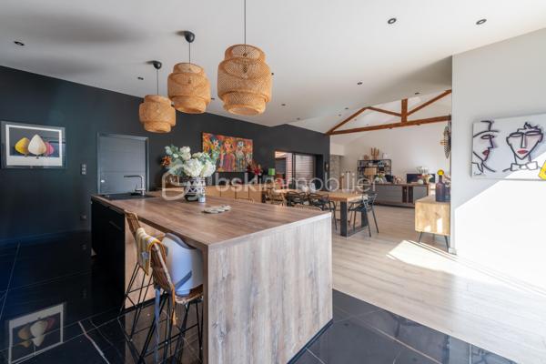 De l’espace pour recevoir, un patio pour s’isoler, une piscine pour profiter des beaux jours… À proximité immédiate du centre-ville de Roanne, cette maison de ville à l’esprit loft conjugue volumes remarquables et douceur de vivre, au calme, en retrait des axes passants.

Réhabilitée en 2021, elle développe environ une surface habitable de 224 m² habitables (surface carrez : 199 m²), sur un terrain clos et arboré de 746 m². Poutres apparentes, belles hauteurs sous plafond et larges ouvertures soulignent le caractère des lieux.

Au cœur de la maison, une pièce de vie d’environ 110 m² réunit cuisine équipée avec îlot central, espace repas et vaste salon. 

Ouverte sur le jardin et la piscine d’un côté, sur le patio intérieur de l’autre, elle invite à vivre autant dedans que dehors.

Le rez-de-chaussée accueille deux chambres donnant sur le patio, dont une suite parentale avec dressing et salle d’eau, ainsi qu’une buanderie et un WC indépendant.

À l’étage, une chambre, une salle de bains avec WC et une seconde pièce disposant d’un point d’eau et d’un WC permettent d’adapter les espaces à vos besoins : quatrième chambre, bureau ou salle de jeux.

À l’extérieur, terrasse, jardin et piscine au sel de 7 × 4 m composent un cadre idéal pour les repas d’été et les moments en famille. Un double carport avec espace de stockage à l’étage complète l’ensemble.

Classée A au DPE, la maison bénéficie d’une pompe à chaleur air/eau, d’un chauffage au sol, de menuiseries à double vitrage renforcé et d’un portail motorisé.

À proximité des écoles, des commerces et de la gare, une maison pour ceux qui souhaitent profiter de la ville tout en conservant de l’espace et un véritable extérieur.