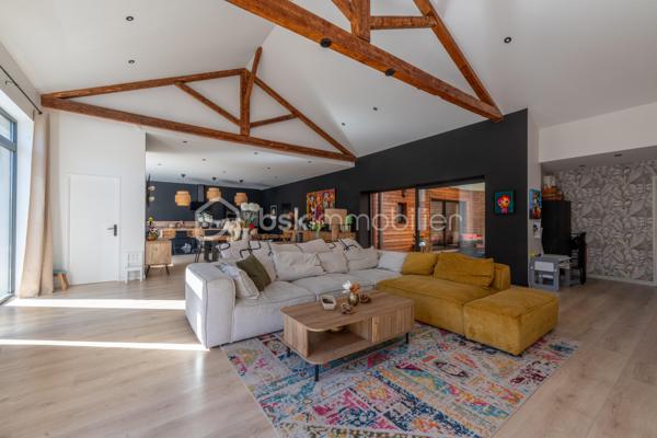 De l’espace pour recevoir, un patio pour s’isoler, une piscine pour profiter des beaux jours… À proximité immédiate du centre-ville de Roanne, cette maison de ville à l’esprit loft conjugue volumes remarquables et douceur de vivre, au calme, en retrait des axes passants.

Réhabilitée en 2021, elle développe environ une surface habitable de 224 m² habitables (surface carrez : 199 m²), sur un terrain clos et arboré de 746 m². Poutres apparentes, belles hauteurs sous plafond et larges ouvertures soulignent le caractère des lieux.

Au cœur de la maison, une pièce de vie d’environ 110 m² réunit cuisine équipée avec îlot central, espace repas et vaste salon. 

Ouverte sur le jardin et la piscine d’un côté, sur le patio intérieur de l’autre, elle invite à vivre autant dedans que dehors.

Le rez-de-chaussée accueille deux chambres donnant sur le patio, dont une suite parentale avec dressing et salle d’eau, ainsi qu’une buanderie et un WC indépendant.

À l’étage, une chambre, une salle de bains avec WC et une seconde pièce disposant d’un point d’eau et d’un WC permettent d’adapter les espaces à vos besoins : quatrième chambre, bureau ou salle de jeux.

À l’extérieur, terrasse, jardin et piscine au sel de 7 × 4 m composent un cadre idéal pour les repas d’été et les moments en famille. Un double carport avec espace de stockage à l’étage complète l’ensemble.

Classée A au DPE, la maison bénéficie d’une pompe à chaleur air/eau, d’un chauffage au sol, de menuiseries à double vitrage renforcé et d’un portail motorisé.

À proximité des écoles, des commerces et de la gare, une maison pour ceux qui souhaitent profiter de la ville tout en conservant de l’espace et un véritable extérieur.