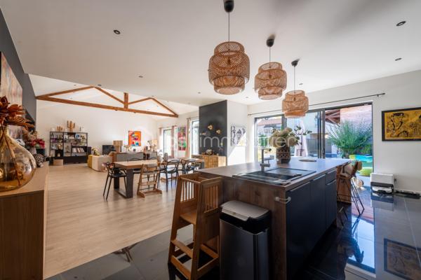De l’espace pour recevoir, un patio pour s’isoler, une piscine pour profiter des beaux jours… À proximité immédiate du centre-ville de Roanne, cette maison de ville à l’esprit loft conjugue volumes remarquables et douceur de vivre, au calme, en retrait des axes passants.

Réhabilitée en 2021, elle développe environ une surface habitable de 224 m² habitables (surface carrez : 199 m²), sur un terrain clos et arboré de 746 m². Poutres apparentes, belles hauteurs sous plafond et larges ouvertures soulignent le caractère des lieux.

Au cœur de la maison, une pièce de vie d’environ 110 m² réunit cuisine équipée avec îlot central, espace repas et vaste salon. 

Ouverte sur le jardin et la piscine d’un côté, sur le patio intérieur de l’autre, elle invite à vivre autant dedans que dehors.

Le rez-de-chaussée accueille deux chambres donnant sur le patio, dont une suite parentale avec dressing et salle d’eau, ainsi qu’une buanderie et un WC indépendant.

À l’étage, une chambre, une salle de bains avec WC et une seconde pièce disposant d’un point d’eau et d’un WC permettent d’adapter les espaces à vos besoins : quatrième chambre, bureau ou salle de jeux.

À l’extérieur, terrasse, jardin et piscine au sel de 7 × 4 m composent un cadre idéal pour les repas d’été et les moments en famille. Un double carport avec espace de stockage à l’étage complète l’ensemble.

Classée A au DPE, la maison bénéficie d’une pompe à chaleur air/eau, d’un chauffage au sol, de menuiseries à double vitrage renforcé et d’un portail motorisé.

À proximité des écoles, des commerces et de la gare, une maison pour ceux qui souhaitent profiter de la ville tout en conservant de l’espace et un véritable extérieur.