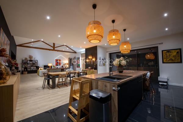 De l’espace pour recevoir, un patio pour s’isoler, une piscine pour profiter des beaux jours… À proximité immédiate du centre-ville de Roanne, cette maison de ville à l’esprit loft conjugue volumes remarquables et douceur de vivre, au calme, en retrait des axes passants.

Réhabilitée en 2021, elle développe environ une surface habitable de 224 m² habitables (surface carrez : 199 m²), sur un terrain clos et arboré de 746 m². Poutres apparentes, belles hauteurs sous plafond et larges ouvertures soulignent le caractère des lieux.

Au cœur de la maison, une pièce de vie d’environ 110 m² réunit cuisine équipée avec îlot central, espace repas et vaste salon. 

Ouverte sur le jardin et la piscine d’un côté, sur le patio intérieur de l’autre, elle invite à vivre autant dedans que dehors.

Le rez-de-chaussée accueille deux chambres donnant sur le patio, dont une suite parentale avec dressing et salle d’eau, ainsi qu’une buanderie et un WC indépendant.

À l’étage, une chambre, une salle de bains avec WC et une seconde pièce disposant d’un point d’eau et d’un WC permettent d’adapter les espaces à vos besoins : quatrième chambre, bureau ou salle de jeux.

À l’extérieur, terrasse, jardin et piscine au sel de 7 × 4 m composent un cadre idéal pour les repas d’été et les moments en famille. Un double carport avec espace de stockage à l’étage complète l’ensemble.

Classée A au DPE, la maison bénéficie d’une pompe à chaleur air/eau, d’un chauffage au sol, de menuiseries à double vitrage renforcé et d’un portail motorisé.

À proximité des écoles, des commerces et de la gare, une maison pour ceux qui souhaitent profiter de la ville tout en conservant de l’espace et un véritable extérieur.