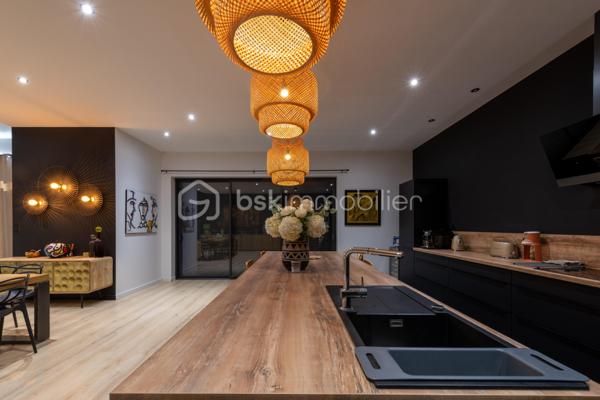 De l’espace pour recevoir, un patio pour s’isoler, une piscine pour profiter des beaux jours… À proximité immédiate du centre-ville de Roanne, cette maison de ville à l’esprit loft conjugue volumes remarquables et douceur de vivre, au calme, en retrait des axes passants.

Réhabilitée en 2021, elle développe environ une surface habitable de 224 m² habitables (surface carrez : 199 m²), sur un terrain clos et arboré de 746 m². Poutres apparentes, belles hauteurs sous plafond et larges ouvertures soulignent le caractère des lieux.

Au cœur de la maison, une pièce de vie d’environ 110 m² réunit cuisine équipée avec îlot central, espace repas et vaste salon. 

Ouverte sur le jardin et la piscine d’un côté, sur le patio intérieur de l’autre, elle invite à vivre autant dedans que dehors.

Le rez-de-chaussée accueille deux chambres donnant sur le patio, dont une suite parentale avec dressing et salle d’eau, ainsi qu’une buanderie et un WC indépendant.

À l’étage, une chambre, une salle de bains avec WC et une seconde pièce disposant d’un point d’eau et d’un WC permettent d’adapter les espaces à vos besoins : quatrième chambre, bureau ou salle de jeux.

À l’extérieur, terrasse, jardin et piscine au sel de 7 × 4 m composent un cadre idéal pour les repas d’été et les moments en famille. Un double carport avec espace de stockage à l’étage complète l’ensemble.

Classée A au DPE, la maison bénéficie d’une pompe à chaleur air/eau, d’un chauffage au sol, de menuiseries à double vitrage renforcé et d’un portail motorisé.

À proximité des écoles, des commerces et de la gare, une maison pour ceux qui souhaitent profiter de la ville tout en conservant de l’espace et un véritable extérieur.