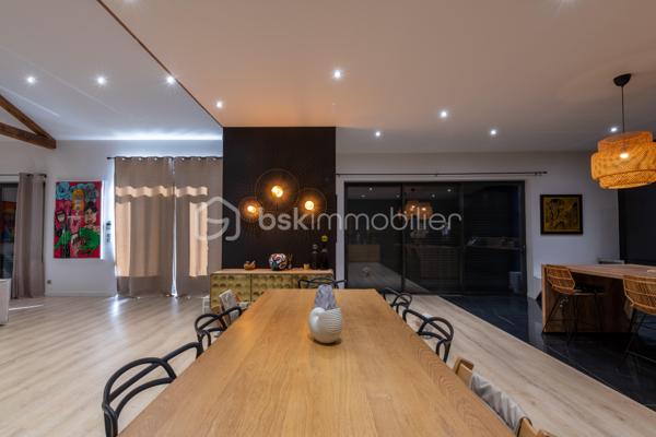 De l’espace pour recevoir, un patio pour s’isoler, une piscine pour profiter des beaux jours… À proximité immédiate du centre-ville de Roanne, cette maison de ville à l’esprit loft conjugue volumes remarquables et douceur de vivre, au calme, en retrait des axes passants.

Réhabilitée en 2021, elle développe environ une surface habitable de 224 m² habitables (surface carrez : 199 m²), sur un terrain clos et arboré de 746 m². Poutres apparentes, belles hauteurs sous plafond et larges ouvertures soulignent le caractère des lieux.

Au cœur de la maison, une pièce de vie d’environ 110 m² réunit cuisine équipée avec îlot central, espace repas et vaste salon. 

Ouverte sur le jardin et la piscine d’un côté, sur le patio intérieur de l’autre, elle invite à vivre autant dedans que dehors.

Le rez-de-chaussée accueille deux chambres donnant sur le patio, dont une suite parentale avec dressing et salle d’eau, ainsi qu’une buanderie et un WC indépendant.

À l’étage, une chambre, une salle de bains avec WC et une seconde pièce disposant d’un point d’eau et d’un WC permettent d’adapter les espaces à vos besoins : quatrième chambre, bureau ou salle de jeux.

À l’extérieur, terrasse, jardin et piscine au sel de 7 × 4 m composent un cadre idéal pour les repas d’été et les moments en famille. Un double carport avec espace de stockage à l’étage complète l’ensemble.

Classée A au DPE, la maison bénéficie d’une pompe à chaleur air/eau, d’un chauffage au sol, de menuiseries à double vitrage renforcé et d’un portail motorisé.

À proximité des écoles, des commerces et de la gare, une maison pour ceux qui souhaitent profiter de la ville tout en conservant de l’espace et un véritable extérieur.