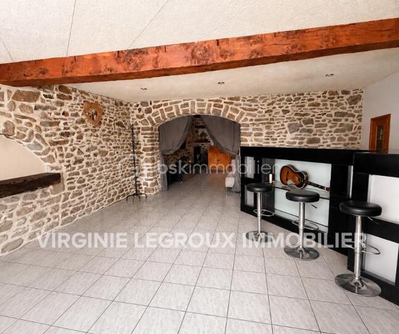 Située à proximité du centre, cette maison en pierre mitoyenne des 2 cotés offre un beau potentiel à ses futurs propriétaires. 
Nous commencerons la visite par la salle de 27m2 avec le charme des murs en pierres apparentes, en enfilade le salon de 20m2 puis toujours en enfilade la cuisine aménagée de 12m2. De la cuisine nous accédons à une cave de 13m2 et au wc séparé de 2m2. Pour un peu plus de rangement, de la cuisine nous accédons à une petite véranda non chauffée qui donne elle accès au jardin. 
Nous poursuivrons avec l'étage. Une mezzanine de 12m2 idéale pour y aménager un bureau ou encore un coin détente distribue l'accès aux trois chambres et à la salle de bain de 6m2 environ. La première chambre fait 14m2 dont un cabinet de toilettes privatif de 2m2 environ, la seconde chambre fait 18m2 et en enfilade vous avez une troisième chambre de 18m2 également. Possibilité de leur donner un accès privatif. 
Nous terminerons la visite par le grenier de 30m2 qui vous offre la possibilité de l'aménager. 
Coté extérieur, vous pourrez profiter de la parcelle de 185m2 entièrement close. Une pergola a été installée pour profiter de ses extérieurs tout en étant protégé. Pas de garage. 
Le mode de chauffage est électrique. La toiture est en ardoises naturelles. Les menuiseries bois sont en double vitrage sauf celle de la cuisine qu'il faudra envisager de changer si vous le souhaitez. La taxe foncière est de 870€. 
Toutes les commodités, écoles et commerces sont à proximité.  
Alors, cette annonce semble correspondre à vos critères de recherche ? Appelez-moi !