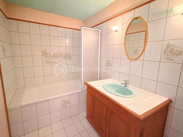 Située à proximité du centre, cette maison en pierre mitoyenne des 2 cotés offre un beau potentiel à ses futurs propriétaires. 
Nous commencerons la visite par la salle de 27m2 avec le charme des murs en pierres apparentes, en enfilade le salon de 20m2 puis toujours en enfilade la cuisine aménagée de 12m2. De la cuisine nous accédons à une cave de 13m2 et au wc séparé de 2m2. Pour un peu plus de rangement, de la cuisine nous accédons à une petite véranda non chauffée qui donne elle accès au jardin. 
Nous poursuivrons avec l'étage. Une mezzanine de 12m2 idéale pour y aménager un bureau ou encore un coin détente distribue l'accès aux trois chambres et à la salle de bain de 6m2 environ. La première chambre fait 14m2 dont un cabinet de toilettes privatif de 2m2 environ, la seconde chambre fait 18m2 et en enfilade vous avez une troisième chambre de 18m2 également. Possibilité de leur donner un accès privatif. 
Nous terminerons la visite par le grenier de 30m2 qui vous offre la possibilité de l'aménager. 
Coté extérieur, vous pourrez profiter de la parcelle de 185m2 entièrement close. Une pergola a été installée pour profiter de ses extérieurs tout en étant protégé. Pas de garage. 
Le mode de chauffage est électrique. La toiture est en ardoises naturelles. Les menuiseries bois sont en double vitrage sauf celle de la cuisine qu'il faudra envisager de changer si vous le souhaitez. La taxe foncière est de 870€. 
Toutes les commodités, écoles et commerces sont à proximité.  
Alors, cette annonce semble correspondre à vos critères de recherche ? Appelez-moi !