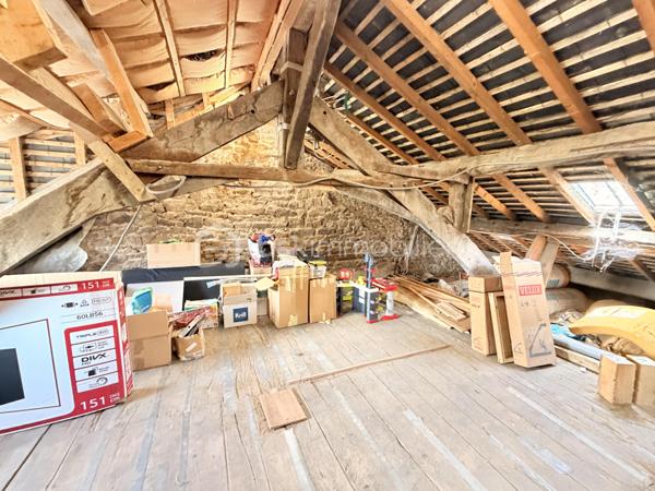 Située à proximité du centre, cette maison en pierre mitoyenne des 2 cotés offre un beau potentiel à ses futurs propriétaires. 
Nous commencerons la visite par la salle de 27m2 avec le charme des murs en pierres apparentes, en enfilade le salon de 20m2 puis toujours en enfilade la cuisine aménagée de 12m2. De la cuisine nous accédons à une cave de 13m2 et au wc séparé de 2m2. Pour un peu plus de rangement, de la cuisine nous accédons à une petite véranda non chauffée qui donne elle accès au jardin. 
Nous poursuivrons avec l'étage. Une mezzanine de 12m2 idéale pour y aménager un bureau ou encore un coin détente distribue l'accès aux trois chambres et à la salle de bain de 6m2 environ. La première chambre fait 14m2 dont un cabinet de toilettes privatif de 2m2 environ, la seconde chambre fait 18m2 et en enfilade vous avez une troisième chambre de 18m2 également. Possibilité de leur donner un accès privatif. 
Nous terminerons la visite par le grenier de 30m2 qui vous offre la possibilité de l'aménager. 
Coté extérieur, vous pourrez profiter de la parcelle de 185m2 entièrement close. Une pergola a été installée pour profiter de ses extérieurs tout en étant protégé. Pas de garage. 
Le mode de chauffage est électrique. La toiture est en ardoises naturelles. Les menuiseries bois sont en double vitrage sauf celle de la cuisine qu'il faudra envisager de changer si vous le souhaitez. La taxe foncière est de 870€. 
Toutes les commodités, écoles et commerces sont à proximité.  
Alors, cette annonce semble correspondre à vos critères de recherche ? Appelez-moi !