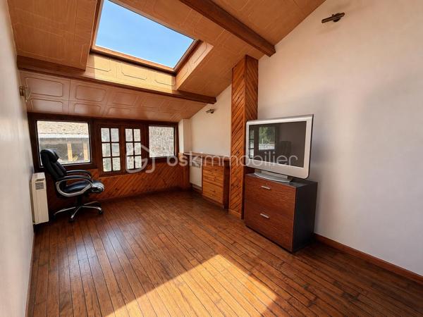 Située à proximité du centre, cette maison en pierre mitoyenne des 2 cotés offre un beau potentiel à ses futurs propriétaires. 
Nous commencerons la visite par la salle de 27m2 avec le charme des murs en pierres apparentes, en enfilade le salon de 20m2 puis toujours en enfilade la cuisine aménagée de 12m2. De la cuisine nous accédons à une cave de 13m2 et au wc séparé de 2m2. Pour un peu plus de rangement, de la cuisine nous accédons à une petite véranda non chauffée qui donne elle accès au jardin. 
Nous poursuivrons avec l'étage. Une mezzanine de 12m2 idéale pour y aménager un bureau ou encore un coin détente distribue l'accès aux trois chambres et à la salle de bain de 6m2 environ. La première chambre fait 14m2 dont un cabinet de toilettes privatif de 2m2 environ, la seconde chambre fait 18m2 et en enfilade vous avez une troisième chambre de 18m2 également. Possibilité de leur donner un accès privatif. 
Nous terminerons la visite par le grenier de 30m2 qui vous offre la possibilité de l'aménager. 
Coté extérieur, vous pourrez profiter de la parcelle de 185m2 entièrement close. Une pergola a été installée pour profiter de ses extérieurs tout en étant protégé. Pas de garage. 
Le mode de chauffage est électrique. La toiture est en ardoises naturelles. Les menuiseries bois sont en double vitrage sauf celle de la cuisine qu'il faudra envisager de changer si vous le souhaitez. La taxe foncière est de 870€. 
Toutes les commodités, écoles et commerces sont à proximité.  
Alors, cette annonce semble correspondre à vos critères de recherche ? Appelez-moi !