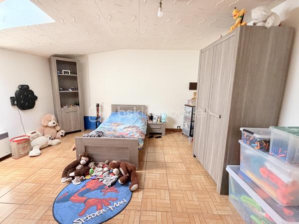 Située à proximité du centre, cette maison en pierre mitoyenne des 2 cotés offre un beau potentiel à ses futurs propriétaires. 
Nous commencerons la visite par la salle de 27m2 avec le charme des murs en pierres apparentes, en enfilade le salon de 20m2 puis toujours en enfilade la cuisine aménagée de 12m2. De la cuisine nous accédons à une cave de 13m2 et au wc séparé de 2m2. Pour un peu plus de rangement, de la cuisine nous accédons à une petite véranda non chauffée qui donne elle accès au jardin. 
Nous poursuivrons avec l'étage. Une mezzanine de 12m2 idéale pour y aménager un bureau ou encore un coin détente distribue l'accès aux trois chambres et à la salle de bain de 6m2 environ. La première chambre fait 14m2 dont un cabinet de toilettes privatif de 2m2 environ, la seconde chambre fait 18m2 et en enfilade vous avez une troisième chambre de 18m2 également. Possibilité de leur donner un accès privatif. 
Nous terminerons la visite par le grenier de 30m2 qui vous offre la possibilité de l'aménager. 
Coté extérieur, vous pourrez profiter de la parcelle de 185m2 entièrement close. Une pergola a été installée pour profiter de ses extérieurs tout en étant protégé. Pas de garage. 
Le mode de chauffage est électrique. La toiture est en ardoises naturelles. Les menuiseries bois sont en double vitrage sauf celle de la cuisine qu'il faudra envisager de changer si vous le souhaitez. La taxe foncière est de 870€. 
Toutes les commodités, écoles et commerces sont à proximité.  
Alors, cette annonce semble correspondre à vos critères de recherche ? Appelez-moi !