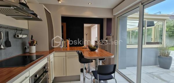 Située dans le quartier recherché de Saint Marc Le Guelmeur, venez découvrir cette très jolie maison de 8 pièces édifiée sur un terrain de 370 m2! Vous serez séduits dès votre arrivée par de beaux volumes et une décoration soignée!
Au rez-de-chaussée, une entrée avec ses placards mène à une très belle pièce de vie et sa cheminée centrale,  celle ci se poursuit par une véranda chauffée qui peut de plus se fermer par une porte en bois à galandage pour s'isoler de la maison si besoin; puis une cuisine dinatoire entièrement équipée avec accès de plain pied au jardin et à la terrasse, le tout très bien entretenu; toujours au rdc, une salle de bains équipée, des toilettes suspendus séparés, et accès au garage par l'intérieur de la maison.
A l'étage, un palier confortable avec espace de rangement dessert  5 chambres parquetées lumineuses (dont une inférieure à 9m2 idéale néanmoins pour un bureau), une salle de douche équipée avec wc. Les huisseries sont en PVC double vitrage, la chaudière au gaz à condensation a été changée il y a deux ans. A noter une très bonne isolation qui permet un DPE  bien classé. Le secteur comme la maison en parfait état correspondront sans aucun doutes à vos attentes! Je suis disponible 7 jours sur 7 pour des visites!  J'attends vos appels!