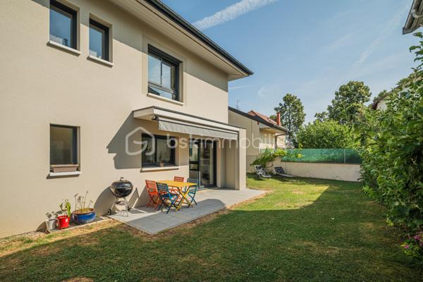 À proximité immédiate du cœur du centre-ville d'Annecy, cette élégante maison mitoyenne par un côté, édifiée en 2023 et à l'architecture contemporaine, conjugue confort moderne et qualité de vie au quotidien.

D'une superficie d'environ 92 m² habitables, l'entrée s'ouvre sur une lumineuse pièce de vie aux volumes harmonieux, où le séjour et la cuisine ouverte se réunissent dans une atmosphère chaleureuse et conviviale. Ce niveau accueille également une salle de douche avec WC ainsi qu'un accès direct au garage depuis l'intérieur de la maison, constituant un véritable confort au quotidien.

L'étage dévoile un espace nuit particulièrement agréable, composé de 3 chambres, dont une avec balcon terrasse, et d'une salle de bains familiale avec WC. 

À l'extérieur, le jardin d'environ 180 m² constitue un prolongement naturel des espaces de vie et promet de beaux moments de détente dès les premiers jours de beau temps.

Pensée pour le bien-être au quotidien, la maison est équipée d'une pompe à chaleur réversible avec plancher chauffant et rafraîchissant. Construite en 2023, elle répond aux dernières normes de construction et de performance énergétique, offrant un confort durable et une consommation énergétique maîtrisée.

Deux places de stationnement privatives ainsi qu'un grand garage avec espace buanderie viennent parfaire ce bien contemporain aux prestations particulièrement soignées.