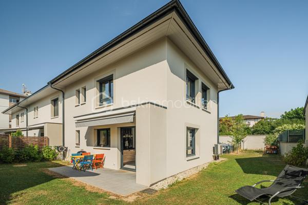 À proximité immédiate du cœur du centre-ville d'Annecy, cette élégante maison mitoyenne par un côté, édifiée en 2023 et à l'architecture contemporaine, conjugue confort moderne et qualité de vie au quotidien.

D'une superficie d'environ 92 m² habitables, l'entrée s'ouvre sur une lumineuse pièce de vie aux volumes harmonieux, où le séjour et la cuisine ouverte se réunissent dans une atmosphère chaleureuse et conviviale. Ce niveau accueille également une salle de douche avec WC ainsi qu'un accès direct au garage depuis l'intérieur de la maison, constituant un véritable confort au quotidien.

L'étage dévoile un espace nuit particulièrement agréable, composé de 3 chambres, dont une avec balcon terrasse, et d'une salle de bains familiale avec WC. 

À l'extérieur, le jardin d'environ 180 m² constitue un prolongement naturel des espaces de vie et promet de beaux moments de détente dès les premiers jours de beau temps.

Pensée pour le bien-être au quotidien, la maison est équipée d'une pompe à chaleur réversible avec plancher chauffant et rafraîchissant. Construite en 2023, elle répond aux dernières normes de construction et de performance énergétique, offrant un confort durable et une consommation énergétique maîtrisée.

Deux places de stationnement privatives ainsi qu'un grand garage avec espace buanderie viennent parfaire ce bien contemporain aux prestations particulièrement soignées.