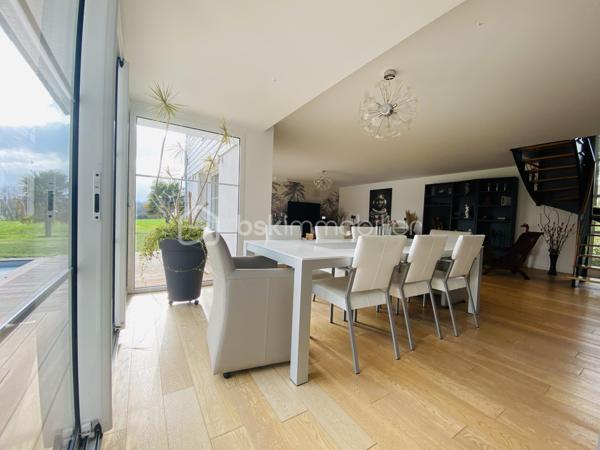Dans un environnement verdoyant, calme et parfaitement préservé des regards, découvrez cette élégante maison familiale de 188 m², édifiée en 2009 sur un terrain clos et arboré de 884 m². 
Elle séduit par ses volumes généreux et ses prestations de qualité.
- Dès l’entrée, vous serez charmé par une vaste pièce de vie d’environ 60 m², lumineuse et conviviale, comprenant une cuisine ouverte et un accès direct à une terrasse idéalement exposée plein sud. 
Les larges baies vitrées renforcent cette sensation d’espace et de lumière.
 À l’extérieur, la terrasse s’ouvre sur une piscine équipée d’une nage à contre-courant et de jets de massage, offrant un véritable espace de détente pour profiter pleinement des beaux jours.
La maison permet une vie de plain-pied grâce à une chambre avec salle d’eau et entrée indépendante, idéale pour une activité professionnelle ou pour recevoir famille et amis en toute autonomie.

- À l’étage, vous trouverez une suite parentale avec dressing et salle d’eau privative, ainsi que trois chambres supplémentaires, dont deux avec balcon commun et un WC indépendant.

Le sous-sol complet propose de beaux espaces fonctionnels : garage, buanderie, local technique et cave à vin.
Le chauffage par géothermie forage assure confort et performance énergétique au quotidien.

Je suis déjà sur place - Mr CHASSIN – 06 71 83 14 47