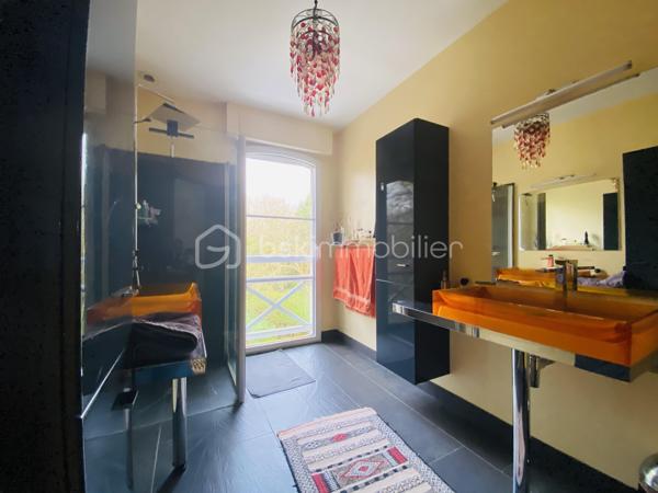 Dans un environnement verdoyant, calme et parfaitement préservé des regards, découvrez cette élégante maison familiale de 188 m², édifiée en 2009 sur un terrain clos et arboré de 884 m². 
Elle séduit par ses volumes généreux et ses prestations de qualité.
- Dès l’entrée, vous serez charmé par une vaste pièce de vie d’environ 60 m², lumineuse et conviviale, comprenant une cuisine ouverte et un accès direct à une terrasse idéalement exposée plein sud. 
Les larges baies vitrées renforcent cette sensation d’espace et de lumière.
 À l’extérieur, la terrasse s’ouvre sur une piscine équipée d’une nage à contre-courant et de jets de massage, offrant un véritable espace de détente pour profiter pleinement des beaux jours.
La maison permet une vie de plain-pied grâce à une chambre avec salle d’eau et entrée indépendante, idéale pour une activité professionnelle ou pour recevoir famille et amis en toute autonomie.

- À l’étage, vous trouverez une suite parentale avec dressing et salle d’eau privative, ainsi que trois chambres supplémentaires, dont deux avec balcon commun et un WC indépendant.

Le sous-sol complet propose de beaux espaces fonctionnels : garage, buanderie, local technique et cave à vin.
Le chauffage par géothermie forage assure confort et performance énergétique au quotidien.

Je suis déjà sur place - Mr CHASSIN – 06 71 83 14 47