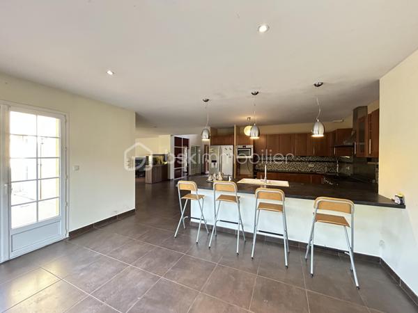 Laissez-vous séduire par cette magnifique villa de 230 m², aux volumes généreux et à la luminosité exceptionnelle, idéalement située à La Verpillière, à proximité immédiate des écoles, commerces et accès autoroutiers.

Dès l’entrée, vous serez charmé par une superbe hauteur cathédrale qui met en valeur les beaux volumes de la maison. Elle s’ouvre sur un vaste espace de vie d’environ 70 m², comprenant un séjour, une salle à manger, une cuisine américaine ouverte et un salon, offrant un cadre de vie convivial et chaleureux.

Au rez-de-chaussée, vous découvrirez également :

Deux chambres, dont une avec salle d’eau privative.
Un WC indépendant.
Une buanderie.
Un garage carrelé et isolé avec porte motorisée.
À l’étage, une mezzanine ouverte sur l’entrée dessert :

Quatre grandes chambres.
Un dressing.
Un WC indépendant avec lave-mains.
Une spacieuse salle de bains équipée d’une double vasque, d’une douche à l’italienne, d’une baignoire et d’un WC.
À l’extérieur, le terrain entièrement clos, arboré et soigneusement aménagé vous permettra de profiter pleinement des beaux jours. Vous bénéficierez également d’une piscine chauffée, sécurisée et entièrement automatisée avec pool house, ainsi que de belles terrasses propices à la détente.

Prestations de qualité :

Plancher chauffant au rez-de-chaussée.
Piscine chauffée et automatisée avec pool house.
Système de vidéosurveillance.
Adoucisseur d’eau.
Volets roulants motorisés.
Visiophone.
Portail motorisé.
Garage isolé avec porte motorisée.
Cette villa est un véritable havre de paix, alliant confort, espace et prestations haut de gamme, dans un environnement recherché à La Verpillière.


À découvrir sans tarder !