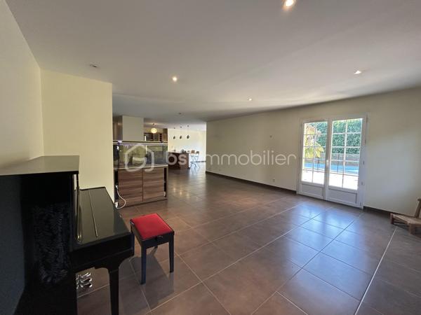 Laissez-vous séduire par cette magnifique villa de 230 m², aux volumes généreux et à la luminosité exceptionnelle, idéalement située à La Verpillière, à proximité immédiate des écoles, commerces et accès autoroutiers.

Dès l’entrée, vous serez charmé par une superbe hauteur cathédrale qui met en valeur les beaux volumes de la maison. Elle s’ouvre sur un vaste espace de vie d’environ 70 m², comprenant un séjour, une salle à manger, une cuisine américaine ouverte et un salon, offrant un cadre de vie convivial et chaleureux.

Au rez-de-chaussée, vous découvrirez également :

Deux chambres, dont une avec salle d’eau privative.
Un WC indépendant.
Une buanderie.
Un garage carrelé et isolé avec porte motorisée.
À l’étage, une mezzanine ouverte sur l’entrée dessert :

Quatre grandes chambres.
Un dressing.
Un WC indépendant avec lave-mains.
Une spacieuse salle de bains équipée d’une double vasque, d’une douche à l’italienne, d’une baignoire et d’un WC.
À l’extérieur, le terrain entièrement clos, arboré et soigneusement aménagé vous permettra de profiter pleinement des beaux jours. Vous bénéficierez également d’une piscine chauffée, sécurisée et entièrement automatisée avec pool house, ainsi que de belles terrasses propices à la détente.

Prestations de qualité :

Plancher chauffant au rez-de-chaussée.
Piscine chauffée et automatisée avec pool house.
Système de vidéosurveillance.
Adoucisseur d’eau.
Volets roulants motorisés.
Visiophone.
Portail motorisé.
Garage isolé avec porte motorisée.
Cette villa est un véritable havre de paix, alliant confort, espace et prestations haut de gamme, dans un environnement recherché à La Verpillière.


À découvrir sans tarder !
