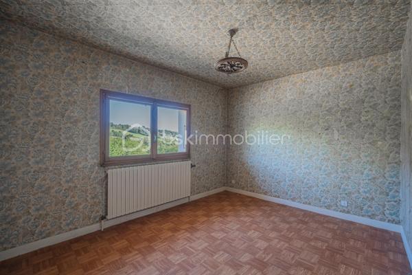 Sur les hauteurs de Rumilly Sud, dans un environnement paisible et verdoyant, cette maison de 131 m² offre un cadre de vie recherché avec une vue dégagée sur les montagnes et la campagne environnante.
Édifiée en 1970 sur un terrain d’environ 1 500 m² exposé Sud-Ouest, elle séduira autant une famille en quête d’espace qu’un artisan ou un amateur de rénovation à la recherche d’un bien à fort potentiel.
La maison bénéficie d’une organisation fonctionnelle et de volumes généreux permettant d’imaginer de nombreux projets d’aménagement.
Le niveau principal accueille une entrée, une cuisine indépendante aménagée, un salon-séjour séparé, trois chambres, une salle d’eau ainsi qu’un WC indépendant. Une vaste terrasse, faisant presque le tour de la maison, prolonge agréablement les espaces de vie et invite à profiter pleinement du panorama et du calme environnant.

À l’étage, deux chambres supplémentaires, une seconde salle d’eau et des greniers ouvrant la porte à différents usages : bureau, espace télétravail, salle de jeux ou pièces complémentaires selon les besoins.
Le sous-sol complet constitue un véritable atout avec un grand garage double, une buanderie avec douche et de larges espaces de rangement ou d’atelier particulièrement appréciables.
À l’extérieur, le terrain et le jardinet clôturé permettent de profiter d’un environnement agréable tout en conservant un entretien raisonnable, avec des stationnements disponibles devant la maison.
Des travaux de remise au goût du jour sont à prévoir, offrant l’opportunité de repenser les espaces et de révéler tout le potentiel de cette maison aux multiples possibilités.
Maison mitoyenne d’un côté, située dans une petite copropriété horizontale de deux lots seulement, sans charges et avec parties entièrement indépendantes.
Chauffage fioul complété par un poêle à bois.
Cette maison s’adresse aux acquéreurs capables de se projeter et recherchant avant tout un environnement calme, de beaux volumes et une vraie liberté de personnalisation.
