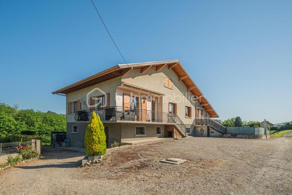 Sur les hauteurs de Rumilly Sud, dans un environnement paisible et verdoyant, cette maison de 131 m² offre un cadre de vie recherché avec une vue dégagée sur les montagnes et la campagne environnante.
Édifiée en 1970 sur un terrain d’environ 1 500 m² exposé Sud-Ouest, elle séduira autant une famille en quête d’espace qu’un artisan ou un amateur de rénovation à la recherche d’un bien à fort potentiel.
La maison bénéficie d’une organisation fonctionnelle et de volumes généreux permettant d’imaginer de nombreux projets d’aménagement.
Le niveau principal accueille une entrée, une cuisine indépendante aménagée, un salon-séjour séparé, trois chambres, une salle d’eau ainsi qu’un WC indépendant. Une vaste terrasse, faisant presque le tour de la maison, prolonge agréablement les espaces de vie et invite à profiter pleinement du panorama et du calme environnant.

À l’étage, deux chambres supplémentaires, une seconde salle d’eau et des greniers ouvrant la porte à différents usages : bureau, espace télétravail, salle de jeux ou pièces complémentaires selon les besoins.
Le sous-sol complet constitue un véritable atout avec un grand garage double, une buanderie avec douche et de larges espaces de rangement ou d’atelier particulièrement appréciables.
À l’extérieur, le terrain et le jardinet clôturé permettent de profiter d’un environnement agréable tout en conservant un entretien raisonnable, avec des stationnements disponibles devant la maison.
Des travaux de remise au goût du jour sont à prévoir, offrant l’opportunité de repenser les espaces et de révéler tout le potentiel de cette maison aux multiples possibilités.
Maison mitoyenne d’un côté, située dans une petite copropriété horizontale de deux lots seulement, sans charges et avec parties entièrement indépendantes.
Chauffage fioul complété par un poêle à bois.
Cette maison s’adresse aux acquéreurs capables de se projeter et recherchant avant tout un environnement calme, de beaux volumes et une vraie liberté de personnalisation.