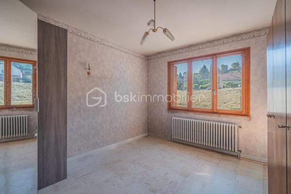 Sur les hauteurs de Rumilly Sud, dans un environnement paisible et verdoyant, cette maison de 131 m² offre un cadre de vie recherché avec une vue dégagée sur les montagnes et la campagne environnante.
Édifiée en 1970 sur un terrain d’environ 1 500 m² exposé Sud-Ouest, elle séduira autant une famille en quête d’espace qu’un artisan ou un amateur de rénovation à la recherche d’un bien à fort potentiel.
La maison bénéficie d’une organisation fonctionnelle et de volumes généreux permettant d’imaginer de nombreux projets d’aménagement.
Le niveau principal accueille une entrée, une cuisine indépendante aménagée, un salon-séjour séparé, trois chambres, une salle d’eau ainsi qu’un WC indépendant. Une vaste terrasse, faisant presque le tour de la maison, prolonge agréablement les espaces de vie et invite à profiter pleinement du panorama et du calme environnant.

À l’étage, deux chambres supplémentaires, une seconde salle d’eau et des greniers ouvrant la porte à différents usages : bureau, espace télétravail, salle de jeux ou pièces complémentaires selon les besoins.
Le sous-sol complet constitue un véritable atout avec un grand garage double, une buanderie avec douche et de larges espaces de rangement ou d’atelier particulièrement appréciables.
À l’extérieur, le terrain et le jardinet clôturé permettent de profiter d’un environnement agréable tout en conservant un entretien raisonnable, avec des stationnements disponibles devant la maison.
Des travaux de remise au goût du jour sont à prévoir, offrant l’opportunité de repenser les espaces et de révéler tout le potentiel de cette maison aux multiples possibilités.
Maison mitoyenne d’un côté, située dans une petite copropriété horizontale de deux lots seulement, sans charges et avec parties entièrement indépendantes.
Chauffage fioul complété par un poêle à bois.
Cette maison s’adresse aux acquéreurs capables de se projeter et recherchant avant tout un environnement calme, de beaux volumes et une vraie liberté de personnalisation.