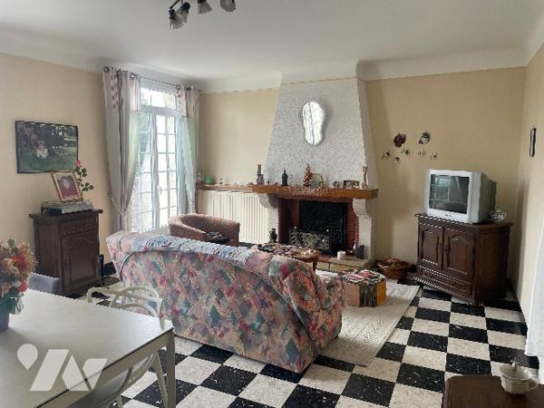 Maison de village avec grand garage et jardin.