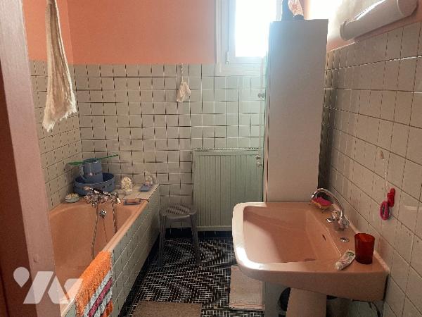 Maison de village avec grand garage et jardin.