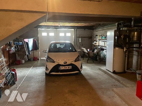 Maison de village avec grand garage et jardin.