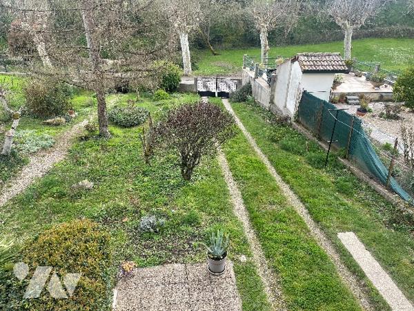 Maison de village avec grand garage et jardin.