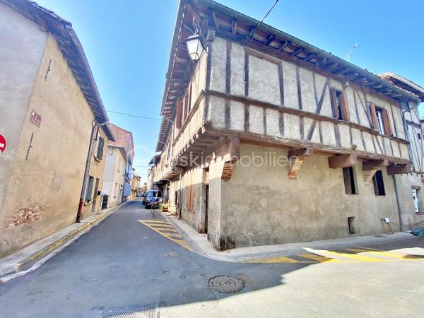 Autant le dire tout de suite : cette maison est entièrement à rénover, et c'est ce qui explique son prix. Inoccupée depuis quelques années, elle demande une remise à niveau complète. Si vous cherchez un bien où poser vos valises, ce n'est pas celle-ci. Cependant, si vous êtes bricoleur ou du métier et qu'un vrai chantier ne vous fait pas peur, vous pouvez lire la suite.
Au cœur de Lisle-sur-Tarn, à pied des commerces, cette maison de village à colombages offre 116 m² : une entrée et un cellier, puis, quelques marches plus haut, à demi-étage, un séjour et un coin cuisine. À l'étage supérieur, trois chambres et une salle d'eau. Il n'y a ni cour, ni jardin, ni garage, et le stationnement se fait dans la rue. La maison est libre, cependant, à mon sens, le bien ne se prête pas à une division en plusieurs logements.
Côté travaux, tout est à reprendre : électricité, isolation, menuiseries, chauffage, cuisine et salle d'eau, avec AU MINIMUM un remaniement de toiture. Les diagnostics relèvent des indices de termites et de l'amiante (dalles de sol à l'étage, conduits en combles). Bonne nouvelle : pas de plomb, et l'assainissement est conforme.
Deux points à connaître avant de vous projeter : la maison se situe dans le périmètre des Bâtiments de France, et la maison accolée fait l'objet d'un arrêté de péril.