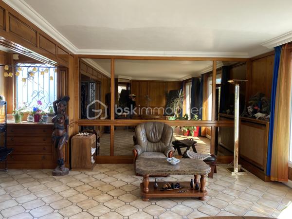 Au cœur du village de Courcouronnes, réputé pour son cadre verdoyant et préservé, à deux pas des grands axes autoroutiers et des transports en commun, se dévoile une propriété rare : une maison familiale de plus de 190 m² habitable (220m2 au sol), nichée au fond d'un chemin privatif, à l'abri des regards.
Franchir ses portes est déjà une invitation au voyage. L'entrée, sublimée par une pierre de Bavière noble et intemporelle, annonce d'emblée l'exigence des matériaux choisis pour cette demeure 

🏡 Une architecture pensée pour la vie de famille

Rez-de-jardin
Une première pièce de 23 m², modulable à l'envi — salle de cinéma, bibliothèque ou espace nuit indépendant. Ce niveau accueille également un vaste cellier, une buanderie et la chaufferie, pour un quotidien organisé avec élégance.

Premier étage — L'art de recevoir
Quelques marches suffisent pour rejoindre la pièce de vie, véritable cœur battant de la maison : un salon-salle à manger (accès terrasse) largement ouvert sur une cuisine aménagée (accès balcon filant permet d’accéder au jardin et à une deuxième terrasse), baigné d'une lumière traversante grâce à de généreuses baies vitrées. Une cheminée signe le caractère unique de cet espace. 
Ce niveau offre aussi deux chambres et une salle d'eau et WC

Deuxième étage — L'intimité préservée
Trois chambres supplémentaires, une salle de bains, un WC indépendant, ainsi qu'un espace mansardé propice à l'aménagement d'un atelier ou d'un bureau. Un escalier discret, accessible depuis la salle de bains, dessert des combles aménagées (grand velux, parquet en bois et lambris sur les murs _ un petit velux en haut des marches, électricité aux normes)— peut servir de salle de jeux, espaces de rangement — offrant une belle réserve de mètres carrés modulables selon vos envies.

Un parc de 3 020 m² pour les amoureux de nature
La parcelle se déploie en un véritable jardin nourricier : potager, poulailler, et une profusion d'arbres floraux et fruitiers composent un cadre bucolique rare à si peu de distance des commodités urbaines.

📍 Une localisation privilégiée
	
🛒 Commerces	3 min à pied
🎒 Écoles maternelle, élémentaire & collège	< 5 min à pied
🎓 Lycées (communes voisines)	Desservis par bus
🚆 Gare RER — Évry-Courcouronnes	5 min en voiture
✈️ Aéroport d'Orly	13 km
TRAM evry-massy	15min à pieds

💎 Le mot de l'agence
Rarement une maison n'aura su conjuguer avec autant de justesse caractère architectural, matériaux nobles et respiration végétale. Un bien à découvrir sans attendre pour les familles en quête d'authenticité, d'espace et de sérénité — à seulement quelques minutes des commodités essentielles.

Contactez-nous dès aujourd'hui pour organiser une visite privée.