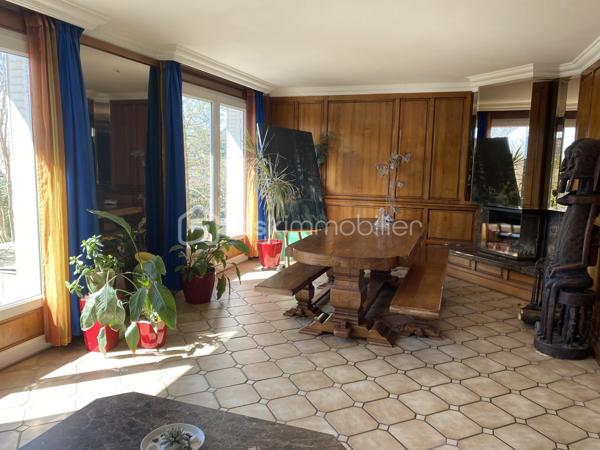 Au cœur du village de Courcouronnes, réputé pour son cadre verdoyant et préservé, à deux pas des grands axes autoroutiers et des transports en commun, se dévoile une propriété rare : une maison familiale de plus de 190 m² habitable (220m2 au sol), nichée au fond d'un chemin privatif, à l'abri des regards.
Franchir ses portes est déjà une invitation au voyage. L'entrée, sublimée par une pierre de Bavière noble et intemporelle, annonce d'emblée l'exigence des matériaux choisis pour cette demeure 

🏡 Une architecture pensée pour la vie de famille

Rez-de-jardin
Une première pièce de 23 m², modulable à l'envi — salle de cinéma, bibliothèque ou espace nuit indépendant. Ce niveau accueille également un vaste cellier, une buanderie et la chaufferie, pour un quotidien organisé avec élégance.

Premier étage — L'art de recevoir
Quelques marches suffisent pour rejoindre la pièce de vie, véritable cœur battant de la maison : un salon-salle à manger (accès terrasse) largement ouvert sur une cuisine aménagée (accès balcon filant permet d’accéder au jardin et à une deuxième terrasse), baigné d'une lumière traversante grâce à de généreuses baies vitrées. Une cheminée signe le caractère unique de cet espace. 
Ce niveau offre aussi deux chambres et une salle d'eau et WC

Deuxième étage — L'intimité préservée
Trois chambres supplémentaires, une salle de bains, un WC indépendant, ainsi qu'un espace mansardé propice à l'aménagement d'un atelier ou d'un bureau. Un escalier discret, accessible depuis la salle de bains, dessert des combles aménagées (grand velux, parquet en bois et lambris sur les murs _ un petit velux en haut des marches, électricité aux normes)— peut servir de salle de jeux, espaces de rangement — offrant une belle réserve de mètres carrés modulables selon vos envies.

Un parc de 3 020 m² pour les amoureux de nature
La parcelle se déploie en un véritable jardin nourricier : potager, poulailler, et une profusion d'arbres floraux et fruitiers composent un cadre bucolique rare à si peu de distance des commodités urbaines.

📍 Une localisation privilégiée
	
🛒 Commerces	3 min à pied
🎒 Écoles maternelle, élémentaire & collège	< 5 min à pied
🎓 Lycées (communes voisines)	Desservis par bus
🚆 Gare RER — Évry-Courcouronnes	5 min en voiture
✈️ Aéroport d'Orly	13 km
TRAM evry-massy	15min à pieds

💎 Le mot de l'agence
Rarement une maison n'aura su conjuguer avec autant de justesse caractère architectural, matériaux nobles et respiration végétale. Un bien à découvrir sans attendre pour les familles en quête d'authenticité, d'espace et de sérénité — à seulement quelques minutes des commodités essentielles.

Contactez-nous dès aujourd'hui pour organiser une visite privée.
