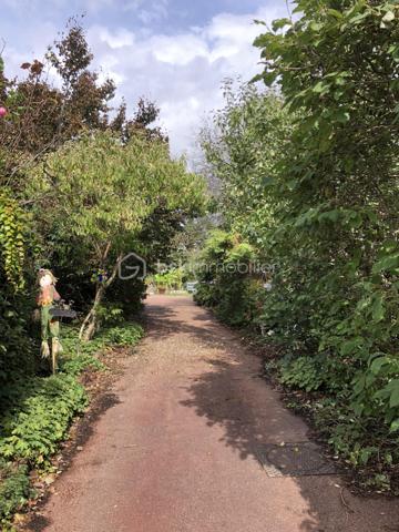 Au cœur du village de Courcouronnes, réputé pour son cadre verdoyant et préservé, à deux pas des grands axes autoroutiers et des transports en commun, se dévoile une propriété rare : une maison familiale de plus de 190 m² habitable (220m2 au sol), nichée au fond d'un chemin privatif, à l'abri des regards.
Franchir ses portes est déjà une invitation au voyage. L'entrée, sublimée par une pierre de Bavière noble et intemporelle, annonce d'emblée l'exigence des matériaux choisis pour cette demeure 

🏡 Une architecture pensée pour la vie de famille

Rez-de-jardin
Une première pièce de 23 m², modulable à l'envi — salle de cinéma, bibliothèque ou espace nuit indépendant. Ce niveau accueille également un vaste cellier, une buanderie et la chaufferie, pour un quotidien organisé avec élégance.

Premier étage — L'art de recevoir
Quelques marches suffisent pour rejoindre la pièce de vie, véritable cœur battant de la maison : un salon-salle à manger (accès terrasse) largement ouvert sur une cuisine aménagée (accès balcon filant permet d’accéder au jardin et à une deuxième terrasse), baigné d'une lumière traversante grâce à de généreuses baies vitrées. Une cheminée signe le caractère unique de cet espace. 
Ce niveau offre aussi deux chambres et une salle d'eau et WC

Deuxième étage — L'intimité préservée
Trois chambres supplémentaires, une salle de bains, un WC indépendant, ainsi qu'un espace mansardé propice à l'aménagement d'un atelier ou d'un bureau. Un escalier discret, accessible depuis la salle de bains, dessert des combles aménagées (grand velux, parquet en bois et lambris sur les murs _ un petit velux en haut des marches, électricité aux normes)— peut servir de salle de jeux, espaces de rangement — offrant une belle réserve de mètres carrés modulables selon vos envies.

Un parc de 3 020 m² pour les amoureux de nature
La parcelle se déploie en un véritable jardin nourricier : potager, poulailler, et une profusion d'arbres floraux et fruitiers composent un cadre bucolique rare à si peu de distance des commodités urbaines.

📍 Une localisation privilégiée
	
🛒 Commerces	3 min à pied
🎒 Écoles maternelle, élémentaire & collège	< 5 min à pied
🎓 Lycées (communes voisines)	Desservis par bus
🚆 Gare RER — Évry-Courcouronnes	5 min en voiture
✈️ Aéroport d'Orly	13 km
TRAM evry-massy	15min à pieds

💎 Le mot de l'agence
Rarement une maison n'aura su conjuguer avec autant de justesse caractère architectural, matériaux nobles et respiration végétale. Un bien à découvrir sans attendre pour les familles en quête d'authenticité, d'espace et de sérénité — à seulement quelques minutes des commodités essentielles.

Contactez-nous dès aujourd'hui pour organiser une visite privée.