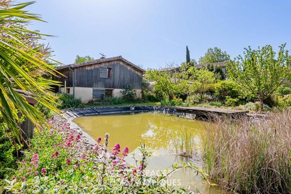 Maison écologique avec bassin naturel et jardin paysager