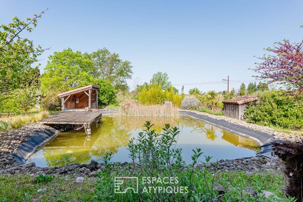 Maison écologique avec bassin naturel et jardin paysager