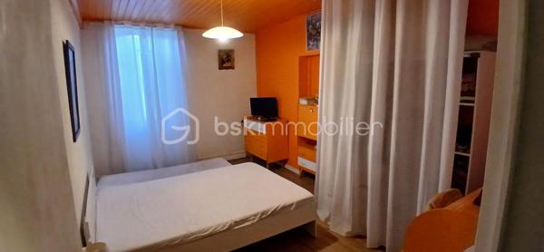 Située dans un petit hameau calme composé de quelques maisons, cette maison pleine de charme offre un cadre de vie paisible et agréable. Devant la maison, un petit auvent permet de se protéger de la pluie, d’y poser les chaussures ou encore d’y stocker un peu de bois. En entrant, on découvre une grande entrée pouvant servir de coin rangement ou de bureau, puis un couloir qui dessert deux chambres, un espace placard et des toilettes séparées. À gauche de l’entrée, le séjour séduit par sa belle luminosité et sa cheminée à foyer ouvert fonctionnelle, idéalement intégrée à une cuisine équipée ouverte, conviviale et pratique. La maison dispose également d’une troisième chambre avec un accès direct à la salle d’eau et son cumulus. Bien qu’en simple vitrage, elle est habitable immédiatement et offre une atmosphère chaleureuse et accueillante. La toiture de la maison a été refaite en 2024, seul le toit du garage reste à prévoir, un devis ayant déjà été établi par une entreprise. Le grand garage de 75 m² offre de nombreuses possibilités d’aménagement ou de stockage. En face de la maison se trouve une partie du terrain arborée avec deuX cabanons en pierre, parfaits pour le rangement ou les petits travaux de jardinage. Une maison authentique, pleine de potentiel, qui n’attend plus que vos idées pour devenir un véritable cocon à la campagne.