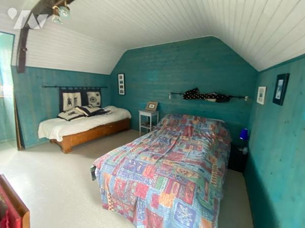 Une maison en pierre composée
Au rdc: une entrée desservant une véranda, un séjour salon, une ...