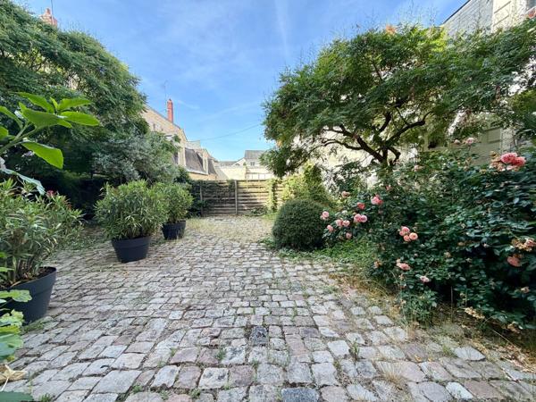 Appartement bourgeois 2 chambres avec cour pavée privative et stationnement sécurisé.