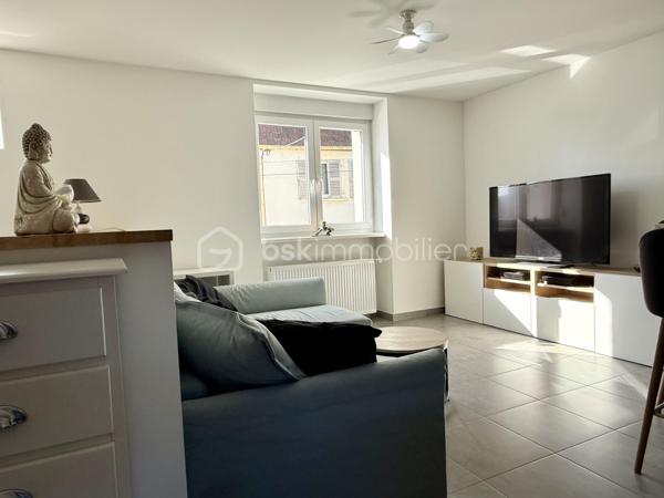 Et si vous profitiez du confort d’une maison entièrement rénovée, sans les contraintes d’un appartement ni les travaux d’une ancienne bâtisse ?

Située en plein cœur de Grosbliederstroff, à proximité immédiate des commerces, commodités et du tram en direction de Sarrebruck, cette maison mitoyenne des deux côtés de 80 m² habitables saura séduire par sa rénovation complète, ses prestations modernes et son agencement particulièrement bien pensé.
Entièrement reconstruite et rénovée il y a environ 8 ans, elle offre aujourd’hui un niveau de confort comparable à celui d’une construction récente : isolation, installations modernisées, double vitrage et chaudière gaz récente.

Dès l’entrée, vous découvrirez un espace de vie agréable et lumineux, composé d’un vaste salon-séjour ouvert sur une cuisine équipée, dans une ambiance contemporaine et conviviale.
Une petite terrasse intérieure, véritable puits de lumière, apporte une touche d’originalité et un agréable espace extérieur à l’abri des regards.
Un espace buanderie ainsi qu’un WC indépendant complètent ce niveau.

À l’étage, l’espace nuit propose deux chambres, un bureau pouvant également accueillir une chambre d’enfant, ainsi qu’une salle d’eau avec douche et WC.

Autre véritable atout : un garage situé sous la maison, accessible par une porte motorisée, offrant un espace de stationnement et de rangement appréciable en plein centre du village.

Côté budget, la maison bénéficie d’une bonne performance énergétique et d’une taxe foncière particulièrement attractive de seulement 483 € par an, ordures ménagères comprises.

Un bien idéal pour celles et ceux qui recherchent une maison fonctionnelle, moderne et facile à vivre, sans jardin, à proximité immédiate de la frontière allemande et des transports, sans avoir à engager de travaux.

Une alternative séduisante à un appartement récent, sans les charges de copropriété, avec le confort et l’indépendance d’une véritable maison !

Wie wäre es, den Komfort eines komplett renovierten Hauses zu genießen – ohne die Einschränkungen einer Wohnung und ohne den Renovierungsaufwand eines Altbaus?

Dieses beidseitig angebaute Haus mit 80 m² Wohnfläche liegt mitten im Ortskern von Grosbliederstroff, in unmittelbarer Nähe zu Geschäften, Einrichtungen des täglichen Bedarfs und der Straßenbahnverbindung nach Saarbrücken. Es besticht durch seine umfassende Renovierung, moderne Ausstattung und eine besonders durchdachte Raumaufteilung.
Das Haus wurde vor etwa acht Jahren grundlegend saniert und bietet heute einen Wohnkomfort, der dem eines Neubaus gleichkommt: zeitgemäße Dämmung, modernisierte Haustechnik, Doppelverglasung und eine neue Gasheizung.

Schon beim Betreten empfängt Sie ein heller, einladender Wohnbereich mit einem großzügigen Wohn- und Esszimmer, das offen in die Einbauküche übergeht – ein modernes und zugleich gemütliches Ambiente.
Eine kleine, innenliegende Terrasse sorgt als Lichtoase für eine besondere Note und bietet einen angenehmen, sichtgeschützten Außenbereich.
Ein Hauswirtschaftsraum sowie ein separates WC vervollständigen diese Ebene.

Im Obergeschoss befindet sich der Schlafbereich mit zwei Zimmern, einem Büro (das sich auch als Kinderzimmer eignet) sowie einem Badezimmer mit Dusche und WC.

Ein weiterer Pluspunkt ist die Garage im Untergeschoss: Sie ist über ein elektrisches Tor zugänglich und bietet wertvollen Stell- und Stauraum mitten im Ortskern.

Auch finanziell überzeugt das Haus durch eine gute Energieeffizienz und eine besonders attraktive Grundsteuer von nur 483 € pro Jahr (inklusive Müllgebühren).

Eine ideale Immobilie für alle, die ein funktionales, modernes und pflegeleichtes Haus ohne Garten suchen – in unmittelbarer Nähe zur deutschen Grenze und zu Verkehrsanbindungen, und das ganz ohne Renovierungsaufwand. Eine attraktive Alternative zu einer modernen Wohnung – ohne das Hausgeld einer Eigentümergemeinschaft, dafür mit dem Komfort und der Unabhängigkeit eines echten Hauses!