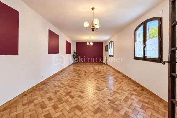 Construite en 1985 et toujours soigneusement entretenue, cette maison de plain-pied est implantée sur un terrain de 454 m².

L'entrée ouvre sur un couloir qui dessert, à droite, une grande pièce de vie d'environ 37 m² sur carrelage, lumineuse et ouverte sur la terrasse. À gauche se trouvent une salle à manger de plus de 15 m² et une cuisine aménagée. La maison comprend également une chambre d'environ 15 m² sur parquet, une salle de bain, un WC séparé et une buanderie-chaufferie.

Une pièce de stockage non chauffée et un accès au vide sanitaire, qui peut servir de rangement, complètent les volumes. L'ensemble offre environ 95m² de potentiel.

La maison bénéficie du double vitrage, de volets battants motorisés, d'une porte de garage sectionnelle motorisée et d'une isolation des combles refaite. Le chauffage est assuré par une chaudière fioul entretenue.

À l'extérieur, vous profiterez de terrasses, d'un jardin arboré et d'un garage sur dalle béton pouvant accueillir deux véhicules.

L'intérieur est à rafraîchir selon vos goûts. C'est une belle opportunité pour une première acquisition, un projet de plain-pied ou un investissement.