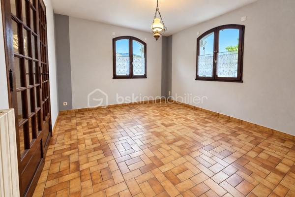 Construite en 1985 et toujours soigneusement entretenue, cette maison de plain-pied est implantée sur un terrain de 454 m².

L'entrée ouvre sur un couloir qui dessert, à droite, une grande pièce de vie d'environ 37 m² sur carrelage, lumineuse et ouverte sur la terrasse. À gauche se trouvent une salle à manger de plus de 15 m² et une cuisine aménagée. La maison comprend également une chambre d'environ 15 m² sur parquet, une salle de bain, un WC séparé et une buanderie-chaufferie.

Une pièce de stockage non chauffée et un accès au vide sanitaire, qui peut servir de rangement, complètent les volumes. L'ensemble offre environ 95m² de potentiel.

La maison bénéficie du double vitrage, de volets battants motorisés, d'une porte de garage sectionnelle motorisée et d'une isolation des combles refaite. Le chauffage est assuré par une chaudière fioul entretenue.

À l'extérieur, vous profiterez de terrasses, d'un jardin arboré et d'un garage sur dalle béton pouvant accueillir deux véhicules.

L'intérieur est à rafraîchir selon vos goûts. C'est une belle opportunité pour une première acquisition, un projet de plain-pied ou un investissement.