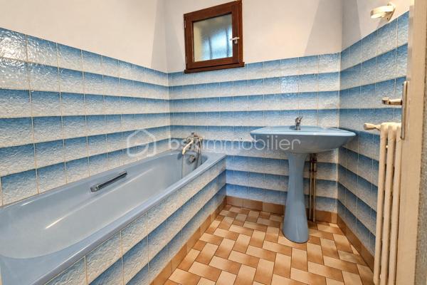 Construite en 1985 et toujours soigneusement entretenue, cette maison de plain-pied est implantée sur un terrain de 454 m².

L'entrée ouvre sur un couloir qui dessert, à droite, une grande pièce de vie d'environ 37 m² sur carrelage, lumineuse et ouverte sur la terrasse. À gauche se trouvent une salle à manger de plus de 15 m² et une cuisine aménagée. La maison comprend également une chambre d'environ 15 m² sur parquet, une salle de bain, un WC séparé et une buanderie-chaufferie.

Une pièce de stockage non chauffée et un accès au vide sanitaire, qui peut servir de rangement, complètent les volumes. L'ensemble offre environ 95m² de potentiel.

La maison bénéficie du double vitrage, de volets battants motorisés, d'une porte de garage sectionnelle motorisée et d'une isolation des combles refaite. Le chauffage est assuré par une chaudière fioul entretenue.

À l'extérieur, vous profiterez de terrasses, d'un jardin arboré et d'un garage sur dalle béton pouvant accueillir deux véhicules.

L'intérieur est à rafraîchir selon vos goûts. C'est une belle opportunité pour une première acquisition, un projet de plain-pied ou un investissement.