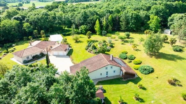 Propriété comprenant deux habitations sur un terrain magnifiquement arboré d'environ 12000m² avec piscine couverte.
