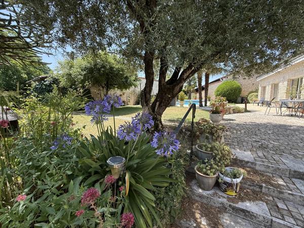 A proximité de Ruffec, magnifique maison en pierre de caractère offrant cinq chambres avec jardin, piscine et dépendances
