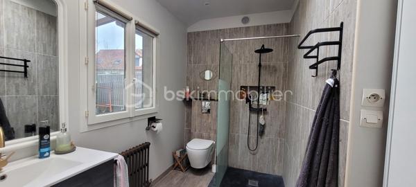 Cette maison offre au rez-de-chaussée une agréable pièce de vie avec cuisine ouverte aménagée et équipée, une salle d'eau avec WC, une buanderie et un garage attenant. À l'étage, un palier desservant trois chambres, dont une chambre parentale disposant de sa salle d'eau privative avec WC. Un jardin complète l'ensemble, idéal pour profiter des beaux jours.
