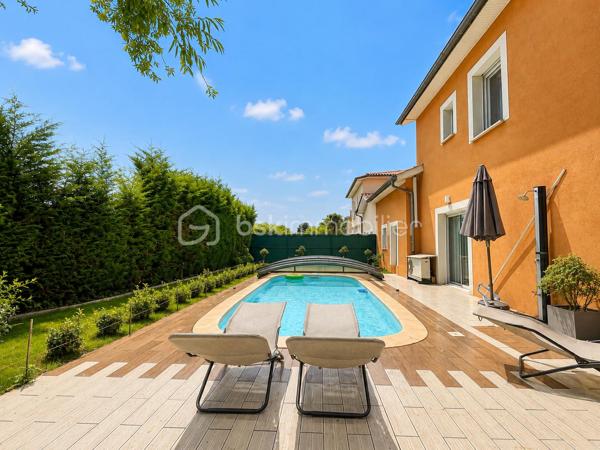 Vous recherchez une maison où poser vos valises sans travaux, profiter d'une piscine en toute intimité et offrir à votre famille un cadre de vie serein ? Cette maison est faite pour vous.
Nichée au fond d'une impasse résidentielle, cette maison contemporaine de 2008 (mitoyenne d'un coté par le garage) d'environ 120m² (110m² Carrez), conçue par un architecte local, séduit dès les premiers instants par son ambiance chaleureuse, sa luminosité exceptionnelle et ses prestations de qualité.

Dès l'entrée, un hall accueillant avec dressing et toilettes invités ouvre sur un superbe espace de vie d'environ 48m². La pièce principale bénéficie d'une triple exposition Est, Sud et Ouest, offrant une luminosité remarquable à toute heure de la journée. Les larges ouvertures prolongent naturellement l'espace vers le jardin et la piscine.
Dans le prolongement du séjour, une élégante véranda chauffée et isolée de 11m² devient une véritable pièce de vie supplémentaire, idéale pour profiter du jardin été comme hiver.
Côté confort, tout a été pensé pour votre bien-être : chauffage au sol par pompe à chaleur, cheminée contemporaine à l'éthanol, excellente performance énergétique classée A et panneaux photovoltaïques permettant de réduire significativement les dépenses énergétiques.
À l'étage, l'espace nuit accueille trois belles chambres, une salle de bains ainsi qu'un second toilette avec rangements. À l'écart, la suite parentale d'environ 25m² offre un espace privilégié, propice au calme et à l'intimité.

Un extérieur conçu pour profiter pleinement : à l'abri des regards et sans aucun vis-à-vis, le terrain plat et joliment arboré de 365m² invite à la détente. Vous profiterez d'une belle terrasse et d'une piscine chauffée par pompe à chaleur (7 x 3,5 m), véritable espace de vie aux beaux jours.

Les atouts qui font la différence :
- En fond d'impasse
- Piscine chauffée sans vis-à-vis
- 4 chambres dont un vaste espace parental
- Pièce de vie lumineuse avec triple exposition
- Véranda chauffée et isolée
- Chauffage au sol par pompe à chaleur
- Panneaux photovoltaïques
- Excellente performance énergétique : Classe A
- Garage de 33m² et 2 stationnements privatifs
- Faible taxe foncière

Le compromis idéal entre calme résidentiel et praticité : accès rapide à l'A46, proximité de la future ligne BHNS reliant Trévoux à Lyon et de toutes les commodités pour simplifier votre quotidien.

Une maison moderne, économe et parfaitement entretenue, offrant un cadre de vie privilégié pour toute la famille.
Les visites s'effectuent exclusivement sur rendez-vous. Contactez-moi dès aujourd'hui pour découvrir cette jolie maison.