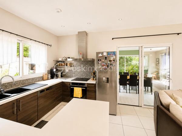 Vous recherchez une maison où poser vos valises sans travaux, profiter d'une piscine en toute intimité et offrir à votre famille un cadre de vie serein ? Cette maison est faite pour vous.
Nichée au fond d'une impasse résidentielle, cette maison contemporaine de 2008 (mitoyenne d'un coté par le garage) d'environ 120m² (110m² Carrez), conçue par un architecte local, séduit dès les premiers instants par son ambiance chaleureuse, sa luminosité exceptionnelle et ses prestations de qualité.

Dès l'entrée, un hall accueillant avec dressing et toilettes invités ouvre sur un superbe espace de vie d'environ 48m². La pièce principale bénéficie d'une triple exposition Est, Sud et Ouest, offrant une luminosité remarquable à toute heure de la journée. Les larges ouvertures prolongent naturellement l'espace vers le jardin et la piscine.
Dans le prolongement du séjour, une élégante véranda chauffée et isolée de 11m² devient une véritable pièce de vie supplémentaire, idéale pour profiter du jardin été comme hiver.
Côté confort, tout a été pensé pour votre bien-être : chauffage au sol par pompe à chaleur, cheminée contemporaine à l'éthanol, excellente performance énergétique classée A et panneaux photovoltaïques permettant de réduire significativement les dépenses énergétiques.
À l'étage, l'espace nuit accueille trois belles chambres, une salle de bains ainsi qu'un second toilette avec rangements. À l'écart, la suite parentale d'environ 25m² offre un espace privilégié, propice au calme et à l'intimité.

Un extérieur conçu pour profiter pleinement : à l'abri des regards et sans aucun vis-à-vis, le terrain plat et joliment arboré de 365m² invite à la détente. Vous profiterez d'une belle terrasse et d'une piscine chauffée par pompe à chaleur (7 x 3,5 m), véritable espace de vie aux beaux jours.

Les atouts qui font la différence :
- En fond d'impasse
- Piscine chauffée sans vis-à-vis
- 4 chambres dont un vaste espace parental
- Pièce de vie lumineuse avec triple exposition
- Véranda chauffée et isolée
- Chauffage au sol par pompe à chaleur
- Panneaux photovoltaïques
- Excellente performance énergétique : Classe A
- Garage de 33m² et 2 stationnements privatifs
- Faible taxe foncière

Le compromis idéal entre calme résidentiel et praticité : accès rapide à l'A46, proximité de la future ligne BHNS reliant Trévoux à Lyon et de toutes les commodités pour simplifier votre quotidien.

Une maison moderne, économe et parfaitement entretenue, offrant un cadre de vie privilégié pour toute la famille.
Les visites s'effectuent exclusivement sur rendez-vous. Contactez-moi dès aujourd'hui pour découvrir cette jolie maison.
