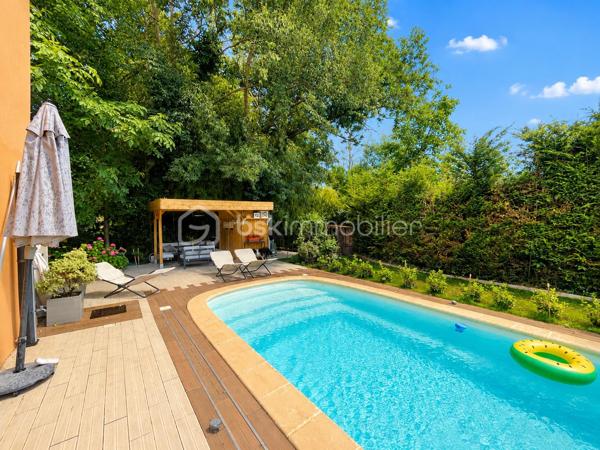 Vous recherchez une maison où poser vos valises sans travaux, profiter d'une piscine en toute intimité et offrir à votre famille un cadre de vie serein ? Cette maison est faite pour vous.
Nichée au fond d'une impasse résidentielle, cette maison contemporaine de 2008 (mitoyenne d'un coté par le garage) d'environ 120m² (110m² Carrez), conçue par un architecte local, séduit dès les premiers instants par son ambiance chaleureuse, sa luminosité exceptionnelle et ses prestations de qualité.

Dès l'entrée, un hall accueillant avec dressing et toilettes invités ouvre sur un superbe espace de vie d'environ 48m². La pièce principale bénéficie d'une triple exposition Est, Sud et Ouest, offrant une luminosité remarquable à toute heure de la journée. Les larges ouvertures prolongent naturellement l'espace vers le jardin et la piscine.
Dans le prolongement du séjour, une élégante véranda chauffée et isolée de 11m² devient une véritable pièce de vie supplémentaire, idéale pour profiter du jardin été comme hiver.
Côté confort, tout a été pensé pour votre bien-être : chauffage au sol par pompe à chaleur, cheminée contemporaine à l'éthanol, excellente performance énergétique classée A et panneaux photovoltaïques permettant de réduire significativement les dépenses énergétiques.
À l'étage, l'espace nuit accueille trois belles chambres, une salle de bains ainsi qu'un second toilette avec rangements. À l'écart, la suite parentale d'environ 25m² offre un espace privilégié, propice au calme et à l'intimité.

Un extérieur conçu pour profiter pleinement : à l'abri des regards et sans aucun vis-à-vis, le terrain plat et joliment arboré de 365m² invite à la détente. Vous profiterez d'une belle terrasse et d'une piscine chauffée par pompe à chaleur (7 x 3,5 m), véritable espace de vie aux beaux jours.

Les atouts qui font la différence :
- En fond d'impasse
- Piscine chauffée sans vis-à-vis
- 4 chambres dont un vaste espace parental
- Pièce de vie lumineuse avec triple exposition
- Véranda chauffée et isolée
- Chauffage au sol par pompe à chaleur
- Panneaux photovoltaïques
- Excellente performance énergétique : Classe A
- Garage de 33m² et 2 stationnements privatifs
- Faible taxe foncière

Le compromis idéal entre calme résidentiel et praticité : accès rapide à l'A46, proximité de la future ligne BHNS reliant Trévoux à Lyon et de toutes les commodités pour simplifier votre quotidien.

Une maison moderne, économe et parfaitement entretenue, offrant un cadre de vie privilégié pour toute la famille.
Les visites s'effectuent exclusivement sur rendez-vous. Contactez-moi dès aujourd'hui pour découvrir cette jolie maison.
