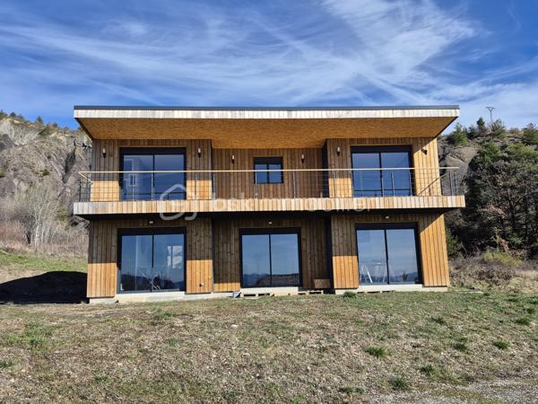 Calme absolu • Vue panoramique dégagée • Climat d'exception • Entre Ciel, Ski et Mer

Au cœur d’un environnement naturel préservé, dans un charmant village particulièrement ensoleillé de Haute-Provence, découvrez cette villa contemporaine en ossature bois de 140 m², pensée comme le refuge idéal pour vos week-ends et vacances. Alliant à la perfection lignes modernes, prestations haut de gamme et intégration paysagère, cette propriété offre un cadre de vie idyllique loin du tumulte urbain.
Une situation stratégique exclusive : à seulement 25 min de Sisteron (accès autoroute), 25 min de l’aérodrome de Tallard, 40 min de Gap, à 1h des stations de ski et à 1h30 de la Méditerranée.

Édifiée sur une parcelle de 802 m², la villa séduit par ses espaces fluides, sa clarté et la qualité de ses matériaux.

•	Le Rez-de-Chaussée (Vie de plain-pied) : L'entrée s’ouvre sur une superbe pièce à vivre de 45 m², véritable cœur de la maison. Elle accueille un salon-salle à manger baigné de lumière et une cuisine neuve de designer, entièrement équipée, ouverte sur le séjour. Ce niveau dispose également d'une suite parentale privative avec sa salle de bains haut de gamme et WC, ainsi que d'une buanderie fonctionnelle.
•	L’Étage (L'espace invités et détente) : Idéal pour recevoir vos proches, l’étage dessert 2 belles chambres spacieuses ainsi qu'un bureau (parfait pour le télétravail au vert). Le joyau architectural : Une magnifique terrasse coursive de 30 m² enveloppe l'étage et distribue l'ensemble des pièces, offrant à chacun un accès extérieur privé et un panorama spectaculaire sur la nature provençale dès le réveil.
•	Annexes & Éco-performance : Un garage de 20 m² avec porte sectionnelle automatisée complète la propriété. Côté confort, la villa est équipée d'un système de chauffage performant et éco-responsable (poêle à granules de dernière génération et chauffe-eau thermodynamique). Le plus : Un Permis de Construire (PC) est déjà accordé pour l'installation de panneaux solaires et d'un abri de jardin haut de gamme.

LA HAUTE-PROVENCE : LA NOUVELLE FRONTIÈRE DU LUXE AUTHENTIQUE

Plus qu'une maison, cette maison vous offre un art de vivre unique. La Haute Provence est devenue l'adresse confidentielle recherchée pour un tourisme nature, authentique et chic.
Depuis votre villa, accédez immédiatement aux plus beaux terrains de jeux outdoor : randonnées pédestres, circuits VTT, sites d'escalade et Via Ferrata, mondialement renommé de la Motte du Caire, ou encore vol à voile avec de nombreux aérodromes et parapente.

Notre avis : Un produit rare sur le marché. L'alliance parfaite entre le confort d'une villa neuve, un entretien facile idéal pour les séjours secondaires, et un emplacement d'exception garantissant une déconnexion totale à moins de deux heures de la Côte d'Azur.

1.	Zéro contrainte : Aucun travaux à prévoir, matériaux durables à faible entretien.
2.	Double saisonnalité rare : Skiez l'hiver à 1h, profitez des lacs et de la mer l'été, randonnez ou grimpez toute l'année sous le soleil légendaire de la Haute-Provence.
3.	Potentiel locatif haut de gamme : Forte demande pour le tourisme sportif et de reconnexion nature (marche, escalade, aéronautique à Tallard).