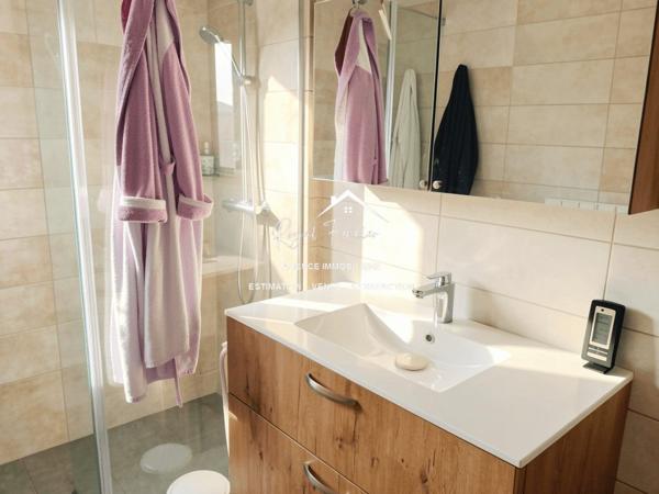 Vue sur la terrasse sous le préau et le jardin