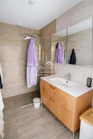 Vue sur la terrasse sous le préau et le jardin